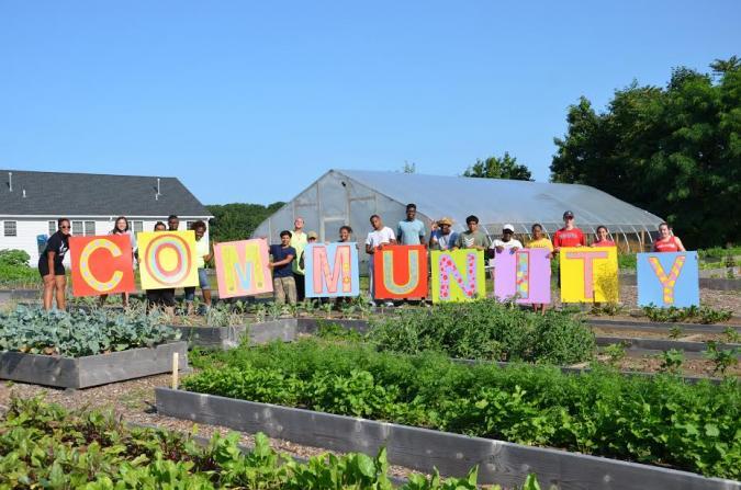 A group of people is holding letters to form the word 'Community'